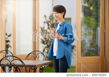 一個女人在一家咖啡館看智能手機 一個女人在一家咖啡館看智能手機 80678089