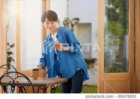 一個女人在一家咖啡館看智能手機 一個女人在一家咖啡館看智能手機 80678091