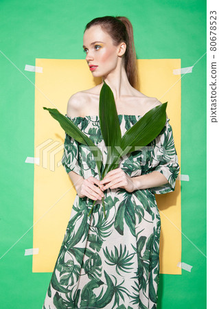 Young woman in summer dress holding leaf 80678523