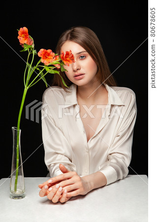 Young woman hiding face behind fresh flowers Young woman hiding face behind fresh flowers 80678605