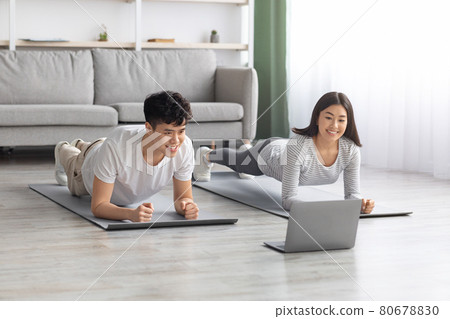 Athletic asian couple having online fitness class 80678830