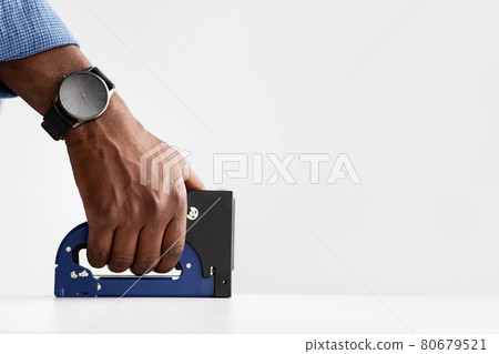 Unrecognizable african american carpenter using staple gun tool making furniture, working with white board, free space 80679521