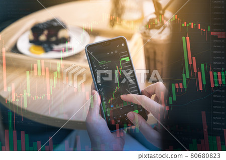 Woman is checking Bitcoin price chart on digital exchange on smartphone in the cafe 80680823