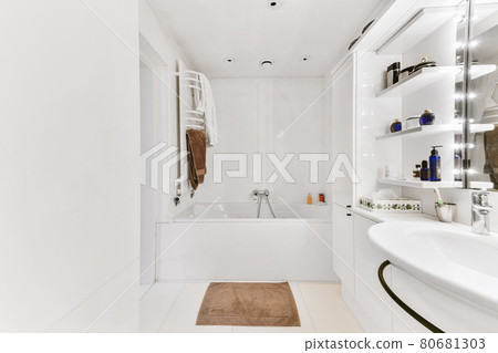 Modern home interior design of light bathroom with white ceramic tiles and bathtub with shower 80681303