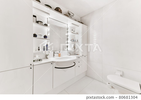 A spacious bathroom with white walls and huge mirror A spacious bathroom with white walls and huge mirror 80681304