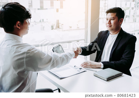 Manager and employee interview concept with handshake after talking about contract signing. Manager and employee interview concept with handshake after talking about contract signing. 80681423