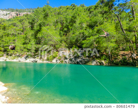 Tourist sliding on a zip line in the canyon of Harmony, near the town of Goynuk and Antalya 80681479