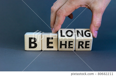 Be here belong symbol. Businessman hand turns cubes and changes words 'be here' to 'belong'. Beautiful grey background. Business, belonging and be here belong concept. Copy space. Be here belong symbol. Businessman hand turns cubes and changes words 'be here' to 'belong'. Beautiful grey background. Business, belonging and be here belong concept. Copy space. 80682211