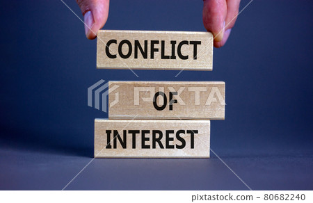 Conflict of interest symbol. Businessman hand. Wooden blocks with words 'conflict of interest'. Beautiful grey background. Copy space. Business and conflict of interest concept. 80682240