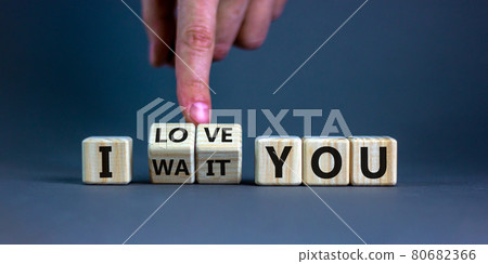 I love you symbol. Hand turns cubes and changes the expression 'I wait you' to 'I love you'. Beautiful grey background, copy space. Psychological and i love you concept. 80682366