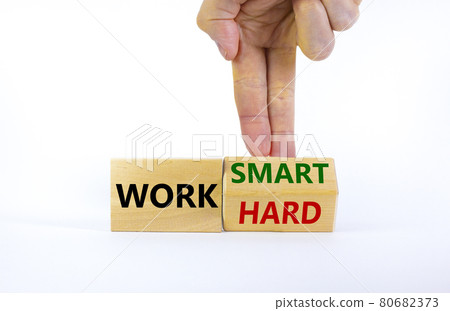 Work hard or smart symbol. Businessman turns wooden block and changes words 'work hard' to 'work smart'. Beautiful white background, copy space. Business and work hard or smart concept. Work hard or smart symbol. Businessman turns wooden block and changes words 'work hard' to 'work smart'. Beautiful white background, copy space. Business and work hard or smart concept. 80682373