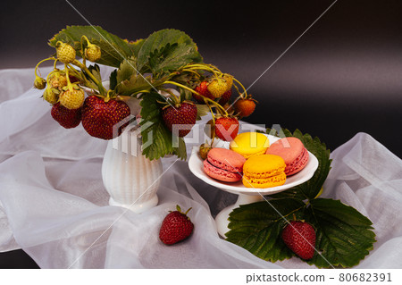 Food dark photography Strawberries and colorful macarons on the white scarf and dramatic dark background. 80682391