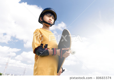 Boy standing with a skateboard 80683374