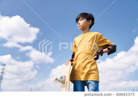 Boy standing with a skateboard 80683375