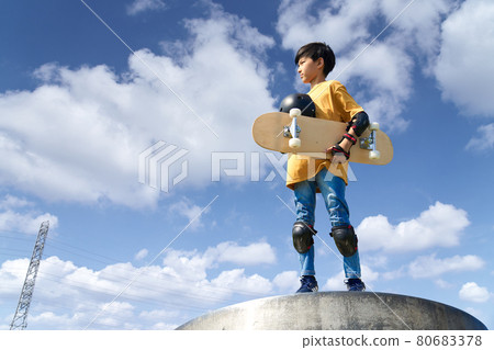 Boy standing with a skateboard 80683378