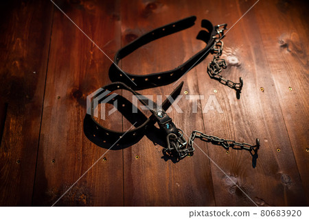 Leather handcuffs for role-playing games lie on a wooden background. bdsm toys for dominantrix. Leather handcuffs for role-playing games lie on a wooden background. bdsm toys for dominantrix. 80683920