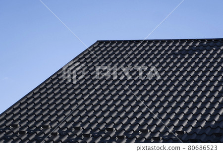 Grey corrugated metal profile roof installed on a modern house. The roof of corrugated sheet. Roofing of metal profile wavy shape. Modern roof made of metal. Metal roofing. 80686523