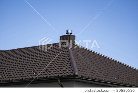 Brown corrugated metal profile roof installed on a modern house. The roof of corrugated sheet. Roofing of metal profile wavy shape. Modern roof made of metal. Metal roofing. 80686556