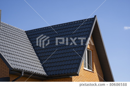 Grey corrugated metal profile roof installed on a modern house. The roof of corrugated sheet. Roofing of metal profile wavy shape. Modern roof made of metal. Metal roofing. 80686588