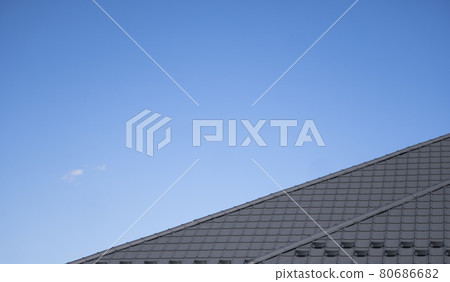 Brown corrugated metal profile roof installed on a modern house. The roof of corrugated sheet. Roofing of metal profile wavy shape. Modern roof made of metal. Metal roofing. 80686682