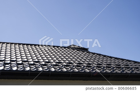 Brown corrugated metal profile roof installed on a modern house. The roof of corrugated sheet. Roofing of metal profile wavy shape. Modern roof made of metal. Metal roofing. Brown corrugated metal profile roof installed on a modern house. The roof of corrugated sheet. Roofing of metal profile wavy shape. Modern roof made of metal. Metal roofing. 80686685