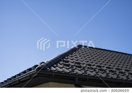 Brown corrugated metal profile roof installed on a modern house. The roof of corrugated sheet. Roofing of metal profile wavy shape. Modern roof made of metal. Metal roofing. 80686689