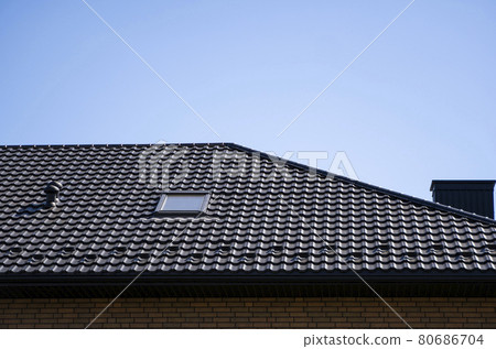 Brown corrugated metal profile roof installed on a modern house. The roof of corrugated sheet. Roofing of metal profile wavy shape. Modern roof made of metal. Metal roofing. 80686704