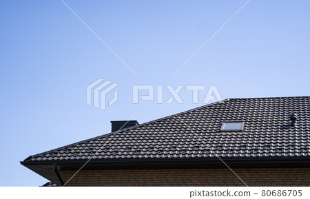 Brown corrugated metal profile roof installed on a modern house. The roof of corrugated sheet. Roofing of metal profile wavy shape. Modern roof made of metal. Metal roofing. Brown corrugated metal profile roof installed on a modern house. The roof of corrugated sheet. Roofing of metal profile wavy shape. Modern roof made of metal. Metal roofing. 80686705