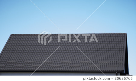 Brown corrugated metal profile roof installed on a modern house. The roof of corrugated sheet. Roofing of metal profile wavy shape. Modern roof made of metal. Metal roofing. Brown corrugated metal profile roof installed on a modern house. The roof of corrugated sheet. Roofing of metal profile wavy shape. Modern roof made of metal. Metal roofing. 80686765