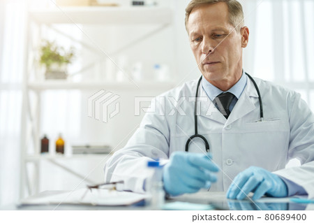 Handsome male doctor working in clinic or healthcare center 80689400