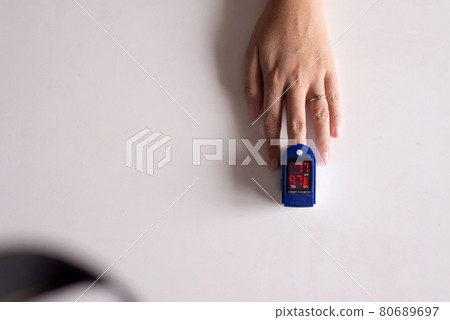Patient woman using fingertip pulse oximeter oxygen saturation meter SPO2 PR blood monitor finger on white background 80689697