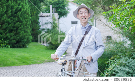 Senior man pushing a bicycle and going out Senior man pushing a bicycle and going out 80689856