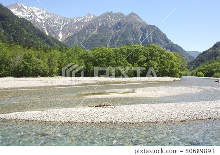 Shinshu Kamikochi, Azusa River surrounded by fresh spring greenery, Hotaka mountain range and Mt. Myojindake in the background 80689891