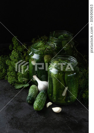 Homemade pickled cucumbers in the glass jar, garlic and fresh dill on black background. Low key photo, copy space Homemade pickled cucumbers in the glass jar, garlic and fresh dill on black background. Low key photo, copy space 80690663