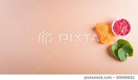 Happy Dussehra. Yellow flowers, green leaf and rice on pastel background. Dussehra Indian Festival concept. 80690682