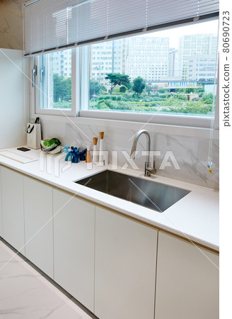 Table and dining table in a clean and simple modern open kitchen Table and dining table in a clean and simple modern open kitchen 80690723