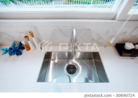 Table and dining table in a clean and simple modern open kitchen Table and dining table in a clean and simple modern open kitchen 80690724