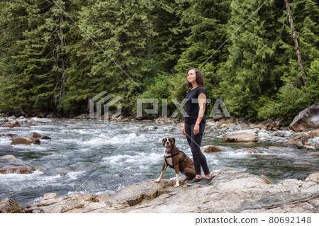 Woman hiking with Boxer Dog in the Canadian Nature Woman hiking with Boxer Dog in the Canadian Nature 80692148