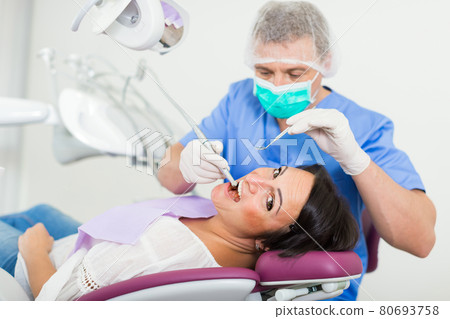 adult dentist checking teeth adult dentist checking teeth 80693758