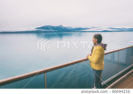Alaska cruise travel tourist looking at mountains landscape from balcony deck of ship. Inside passage Glacier bay scenic vacation travel woman enjoying scenery from boat 80694258