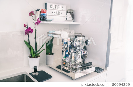 Home kitchen decor coffee bar for espresso machine on countertop, modern apartment living, wall shelves, orchid flower, indoor lifestyle 80694299