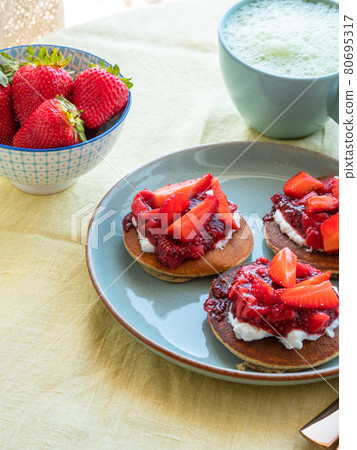 Vegan buckwheat gluten free pancakes breakfast served with chia strawberry jam and dairy free yogurt 80695317