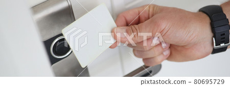 Man applies magnetic key to electronic door lock 80695729