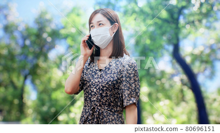 A woman in a one-piece standing in front of the trees A woman in a one-piece standing in front of the trees 80696151