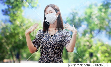 A woman in a one-piece standing in front of the trees 80696152