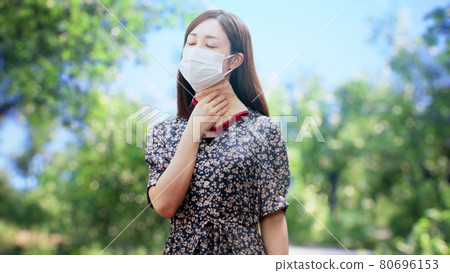 A woman in a one-piece standing in front of the trees A woman in a one-piece standing in front of the trees 80696153