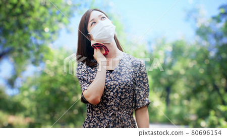 A woman in a one-piece standing in front of the trees A woman in a one-piece standing in front of the trees 80696154