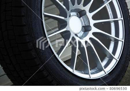 The front side of the winter tire wheel is washed with water 80696530
