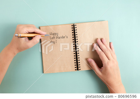 Happy Left Hander's Day. Left hand hold pen and writing text. Happy Left Hander's Day. Left hand hold pen and writing text. 80696596