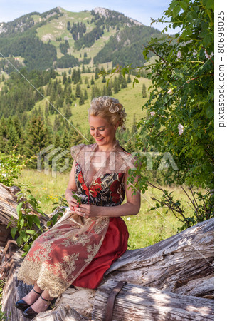 Woman in festive dirndl, romantic in alps. Woman in festive dirndl, romantic in alps. 80698025